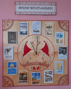 Стенд с таким названием появился в Мезенской библиотеке в рамках смотра-конкурса по оформлению внутреннего пространства и прилегающей территории среди учреждений культуры района. Стрелки часов на нем указывают точное время — «Время читать наших».