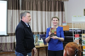 Подарок муниципальным и школьным библиотекам района. И. А. Чесноков дарит книгу "Мой Верхнетоемский район" Комаровой Н. В.